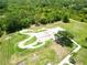Aerial view of community skate park featuring smooth concrete ramps, green turf, and a surrounding walking path at 15101 Kestrelglen Way, Lithia, FL 33547