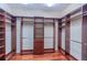 Large walk-in closet with custom wood shelving and hanging rods for ample storage space at 15101 Kestrelglen Way, Lithia, FL 33547