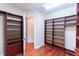 Spacious walk-in closet featuring custom wood shelving with drawers and ample storage space at 15101 Kestrelglen Way, Lithia, FL 33547