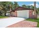 Front view of a brick-accented home featuring an attached two-car garage and well-maintained driveway at 166 11Th N Ave, Safety Harbor, FL 34695