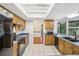 Kitchen with wood cabinets and black appliances featuring view to hardwood dining room at 166 11Th N Ave, Safety Harbor, FL 34695
