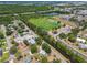 An aerial shot displays homes with a soccer field and a body of water nearby at 1810 77Th N Ave, St Petersburg, FL 33702