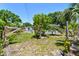 Backyard view includes the home's exterior, a wooden fence, and mature trees at 1810 77Th N Ave, St Petersburg, FL 33702