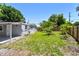 Backyard view features the home's exterior and a green lawn with mature trees at 1810 77Th N Ave, St Petersburg, FL 33702