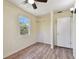 Comfortable bedroom with wood-look floors, ceiling fan, closet, and sunlit window at 1810 77Th N Ave, St Petersburg, FL 33702