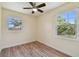 Bright bedroom with wood-look floors, ceiling fan, and natural light from two windows at 1810 77Th N Ave, St Petersburg, FL 33702
