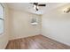 Cozy bedroom with wood-look flooring, ceiling fan, and a bright window at 1810 77Th N Ave, St Petersburg, FL 33702