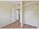 Cozy bedroom features wood-look flooring, closet with shelves, and open doorway at 1810 77Th N Ave, St Petersburg, FL 33702