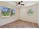Bright bedroom featuring wood-look flooring, a ceiling fan, and two windows offering natural light at 1810 77Th N Ave, St Petersburg, FL 33702