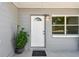 Close-up of the front door area with an ornamental plant, showing fresh paint and updated hardware at 1810 77Th N Ave, St Petersburg, FL 33702