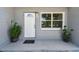 Inviting front entrance with a white door, plants, and a secure front porch at 1810 77Th N Ave, St Petersburg, FL 33702