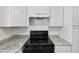 Kitchen features black oven, granite countertops and white cabinets at 1810 77Th N Ave, St Petersburg, FL 33702