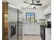 The kitchen features white cabinets, granite counters, stainless steel appliances, and a window view at 1810 77Th N Ave, St Petersburg, FL 33702