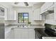 Kitchen features granite counters, stainless steel sink, and white cabinets at 1810 77Th N Ave, St Petersburg, FL 33702