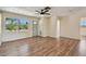 Bright living room with wood-look flooring, ceiling fan, and large window offering ample natural light at 1810 77Th N Ave, St Petersburg, FL 33702