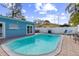 Backyard pool with lounge chairs, grill, and a privacy fence creates a private oasis for relaxation and outdoor enjoyment at 1818 Indian Rocks Rd S, Largo, FL 33774