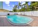 Large backyard pool with lounge chairs, grill, a white privacy fence, and tropical landscaping create a relaxing retreat at 1818 Indian Rocks Rd S, Largo, FL 33774