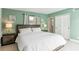 Bedroom with green walls, white comforter and wood bedside tables and a neutral decor at 1818 Indian Rocks Rd S, Largo, FL 33774