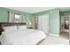 Bedroom with green walls, and white comforter and access to an adjacent room at 1818 Indian Rocks Rd S, Largo, FL 33774