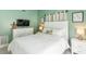 Main bedroom features white furniture, TV, decor, and natural lighting at 1818 Indian Rocks Rd S, Largo, FL 33774