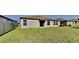 A well-maintained backyard with green grass and sliding glass doors leading to the home at 1881 Colding Dr, Ruskin, FL 33570