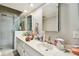 Bright bathroom featuring a double sink vanity with marble counters and a glass-enclosed walk-in shower at 19010 Gulf Blvd # 203, Indian Shores, FL 33785