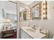 Bathroom vanity featuring a sink, white cabinets, decorative mirrors, and sconce lighting at 19010 Gulf Blvd # 203, Indian Shores, FL 33785