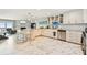 Bright kitchen with stainless steel appliances, island and fireplace in attached living area at 19010 Gulf Blvd # 203, Indian Shores, FL 33785