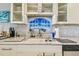 Well lit kitchen sink with stainless steel faucet and mosaic tile backsplash at 19010 Gulf Blvd # 203, Indian Shores, FL 33785