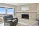 Living room with gray recliner and brick fireplace, sliding doors to deck with ocean view at 19010 Gulf Blvd # 203, Indian Shores, FL 33785