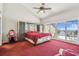 Large primary bedroom with balcony access, ceiling fan, and water view at 19010 Gulf Blvd # 203, Indian Shores, FL 33785
