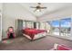 Large primary bedroom with balcony access, ceiling fan, and ocean view at 19010 Gulf Blvd # 203, Indian Shores, FL 33785