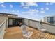 Outdoor deck area with two chairs and views of nearby buildings and landscape at 19010 Gulf Blvd # 203, Indian Shores, FL 33785