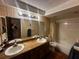 Functional bathroom featuring a double sink vanity with a large mirror and a shower and bathtub combo at 213 Mahogany Dr, Seffner, FL 33584