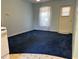 Bright room with blue carpet, lots of light from the window, and a door to the outside at 213 Mahogany Dr, Seffner, FL 33584
