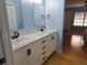 Bathroom features a double sink vanity, modern fixtures, blue walls and hardwood floors at 2615 Southern Oaks Pl, Plant City, FL 33566