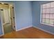 A bedroom with wood flooring, light blue walls, and access to the bathroom at 2615 Southern Oaks Pl, Plant City, FL 33566