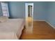 A bedroom with wood flooring, light blue walls, and access to the bathroom at 2615 Southern Oaks Pl, Plant City, FL 33566