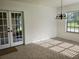 Bright dining room with wainscoting, glass doors, and a chandelier at 2615 Southern Oaks Pl, Plant City, FL 33566