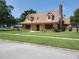 Charming two-story home with a brick chimney, dormer windows, and a covered front porch at 2615 Southern Oaks Pl, Plant City, FL 33566
