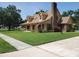 Two-story home featuring a manicured lawn, brick chimney, covered porch, and dormer windows at 2615 Southern Oaks Pl, Plant City, FL 33566