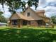 Beautiful two-story home with brick siding, green lawn, and dormer windows at 2615 Southern Oaks Pl, Plant City, FL 33566