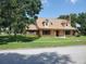 Quaint two-story home with dormer windows, covered porch, and a brick chimney at 2615 Southern Oaks Pl, Plant City, FL 33566