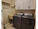 Laundry room with washer, dryer, white cabinets, and patterned floors at 2615 Southern Oaks Pl, Plant City, FL 33566
