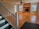 Bright living room with gleaming hardwood floors, a staircase, and a brick fireplace creating a welcoming atmosphere at 2615 Southern Oaks Pl, Plant City, FL 33566