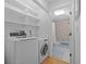 Well-lit laundry room with washer, dryer, and storage shelves, connected to a clean, bright bathroom with shower at 2665 Sequoia Ter # 306, Palm Harbor, FL 34683