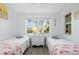 Charming bedroom features two twin beds, natural light from window, and decorative elements creating a serene atmosphere at 2665 Sequoia Ter # 306, Palm Harbor, FL 34683