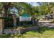 Welcoming Laurel Oaks entrance with lush landscaping, signage, brick columns and black iron fencing at 2665 Sequoia Ter # 306, Palm Harbor, FL 34683