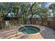 Community hot tub and spa on a brick deck with an access rail and decorative landscaping at 2665 Sequoia Ter # 306, Palm Harbor, FL 34683