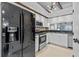Modern kitchen with white cabinetry, black appliances, and granite countertops at 2665 Sequoia Ter # 306, Palm Harbor, FL 34683